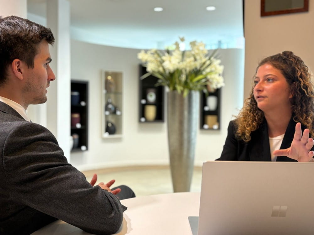 Twee DELA medewerkers bespreken iets aan tafel
